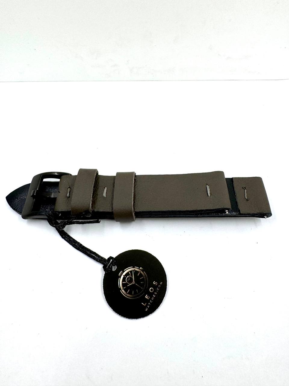 Cinturino Artigianale Essential 18mm — Vera Pelle Verde Militare con Interno Nero e Fibbia Nera PVD — Vista laterale spessore con passanti verdi e tag LeosWatches
